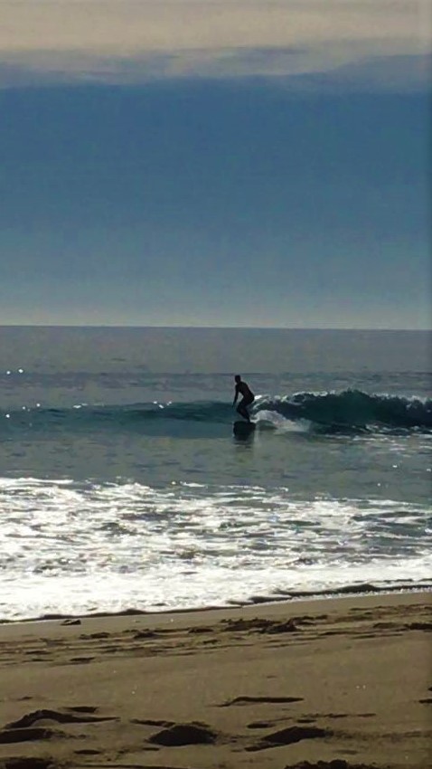 annemarie surfing a sweet longboard wave at Porto de Mos
