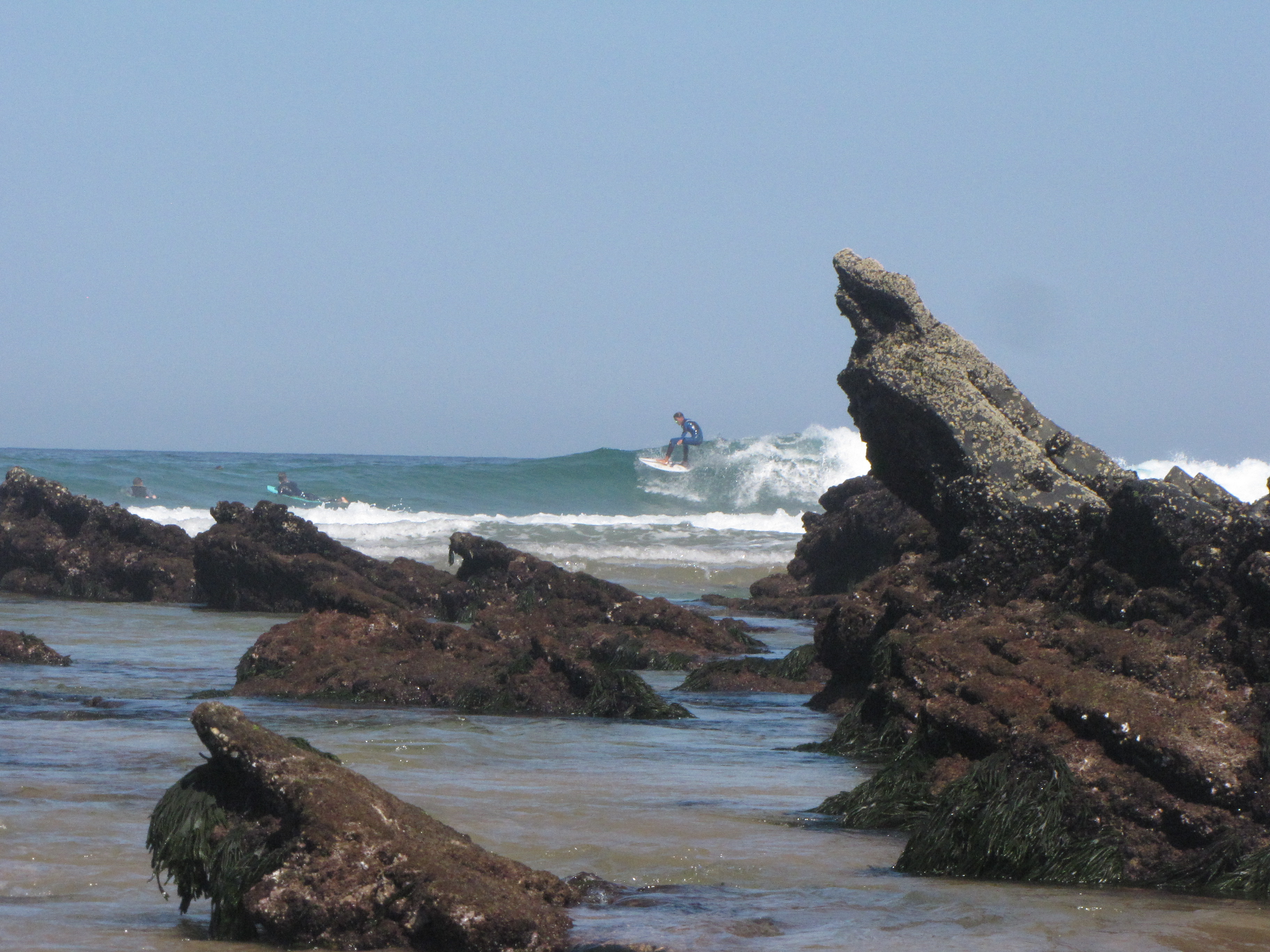 rocks and surfer on a nice blue wave in the algarve