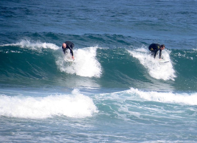 father and son splitting peak surfing with surf guide algarve