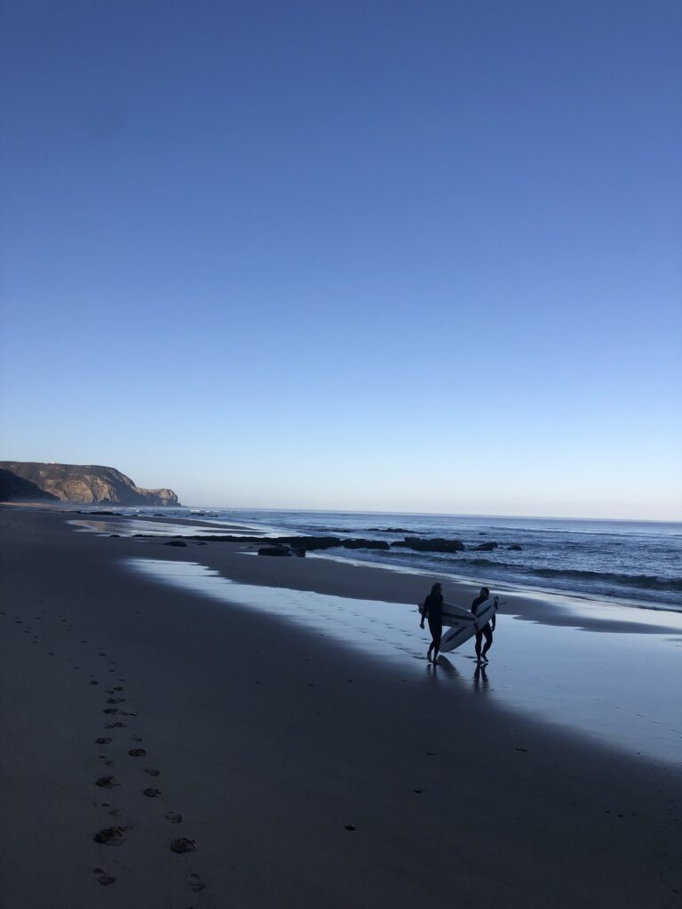 surfers walk on the beach surf guide algarve