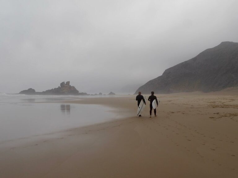 surfers on the beach of castelejo surf guide algarve