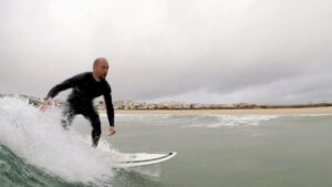 surf guide algarve guest enjoying the clean waves in lagos meia praia
