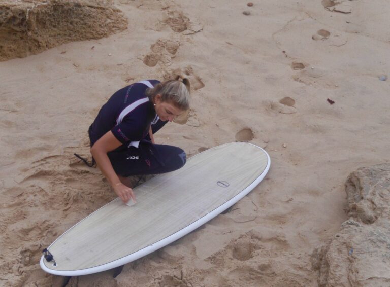 waxing down the surfboasr surf girl with surf guide algarve