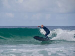 surf guide algarve friend styling on his longboard at zavial